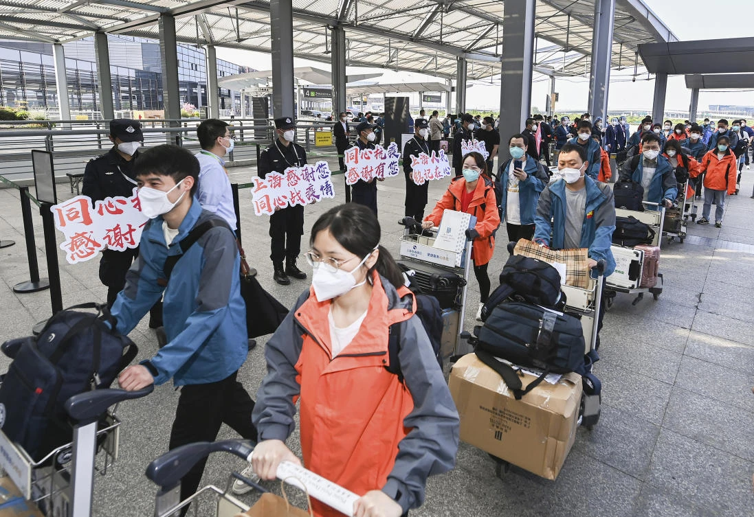 Members of a COVID-19 testing team are greeted at an airport in Shanghai as they prepare to return home to Hubei Province on May 14, 2022. (Xinhua via AP)