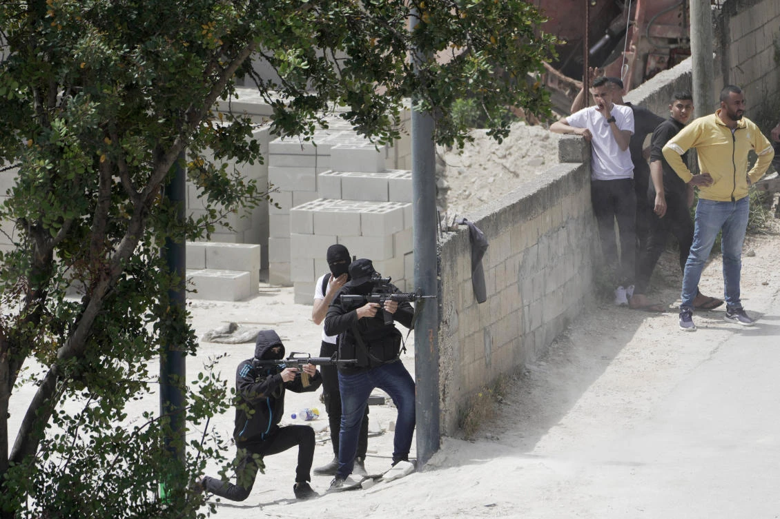 Palestinian gunmen take aim during an Israeli military operation in the West Bank town of Jenin on Friday, May 13, 2022. (AP)