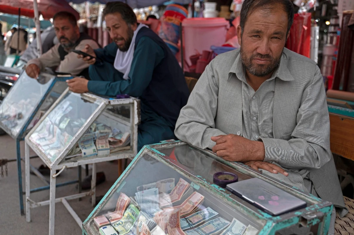 Afghan money changers wait for customers along a street near the currency exchange Sarai Shahzada market in Kabul on Sunday. AFP