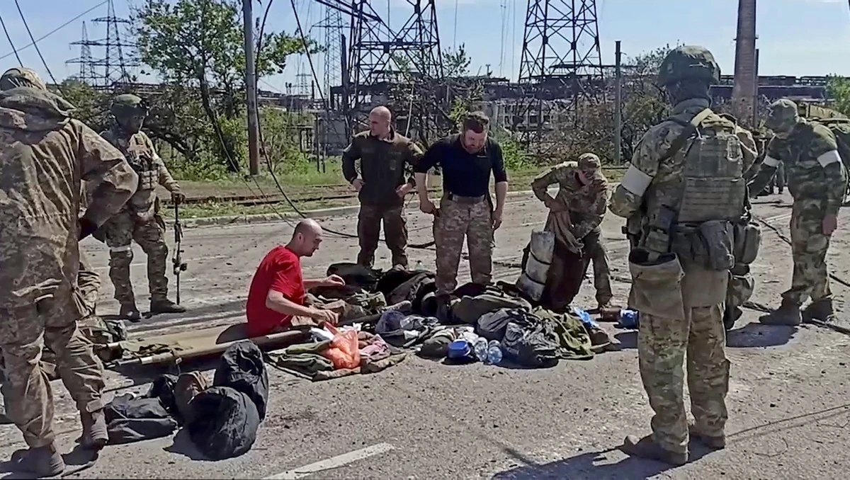 Service members of Ukrainian forces who have surrendered are searched by the pro-Russian military in Mariupol, Ukraine. (Reuters)