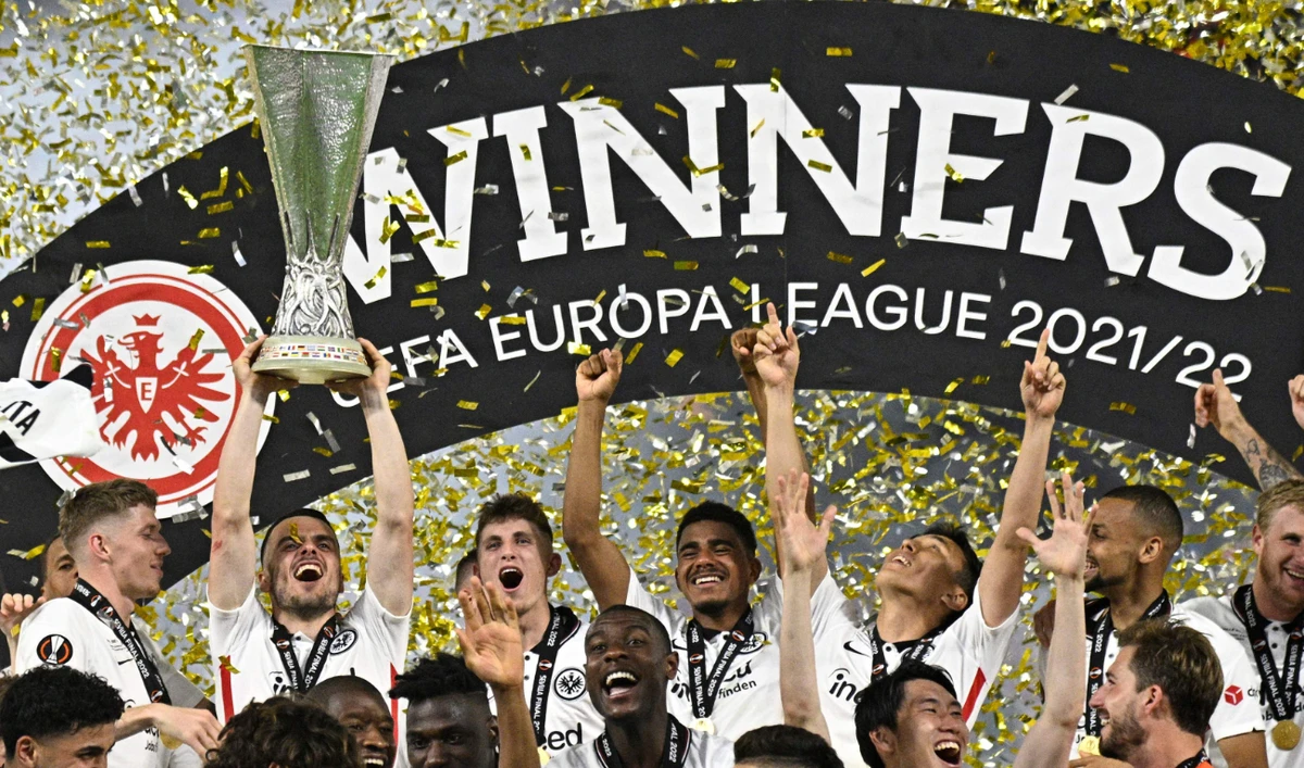 Frankfurt's midfielder Kostic lifts the trophy as Frankfurt players celebrate after winning the UEFA Europa League final football match against Glasgow Rangers in Seville on May 18, 2022. (AFP)