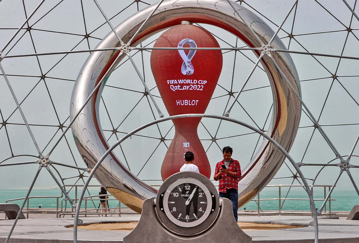 People stand by the clock installation ticking the days to the start of the Qatar 2022 FIFA World Cup in Qatar's capital Doha on May 17, 2022. (AFP)