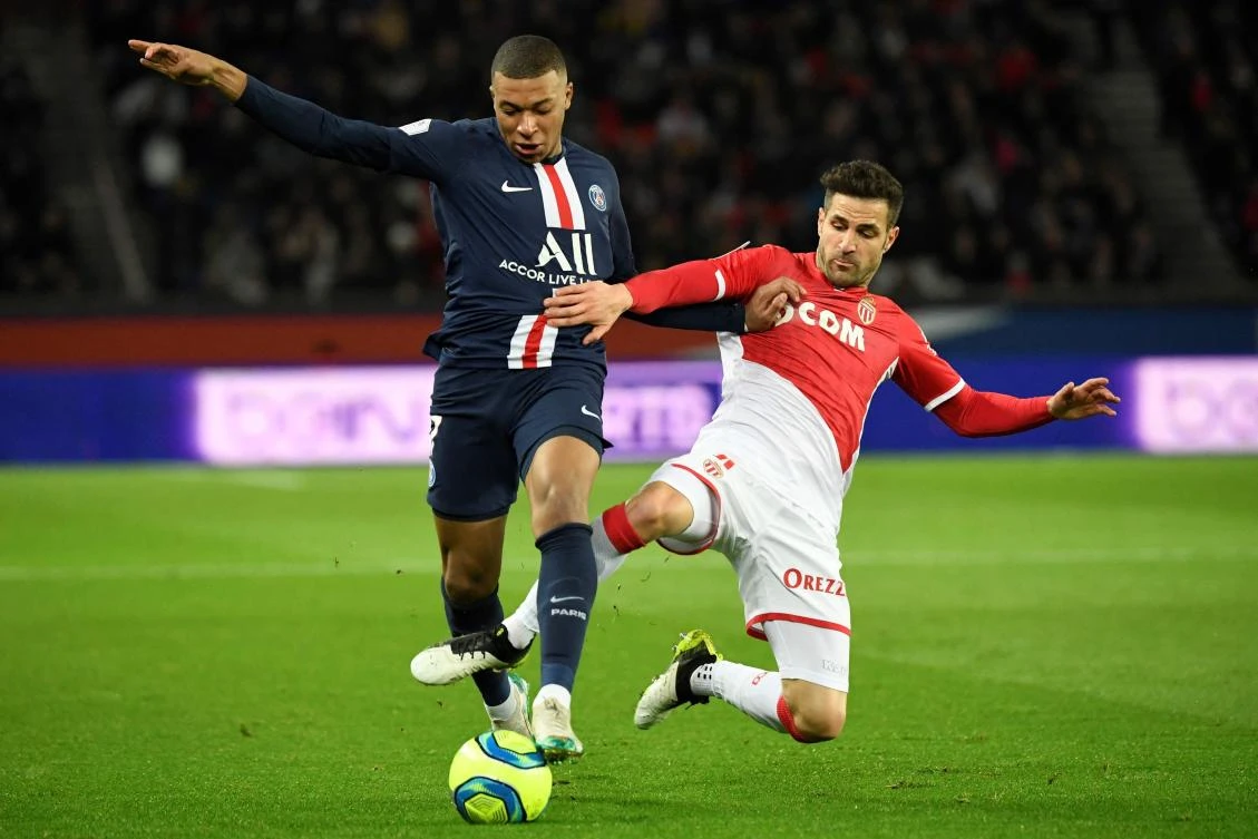 Paris Saint-Germain’s French forward Kylian Mbappe fights for the ball against Monaco’s Spanish midfielder Cesc Fabregas during their French L1 match in 2020. (AFP)