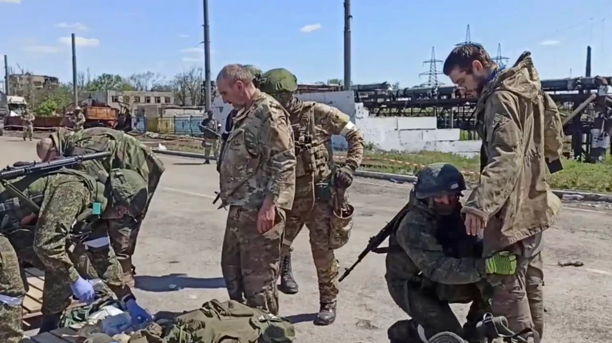 Russian servicemen frisk Ukrainian servicemen after they left the besieged Azovstal steel plant in Mariupol, eastern Ukraine. (File/AP)