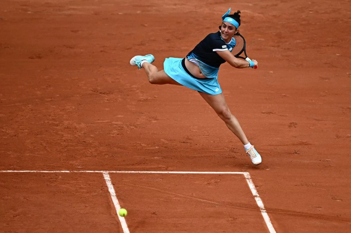 Ons Jabeur plays a forehand return to Magda Linette during their singles match on Court Philippe-Chatrier, Roland-Garros, Paris, France, May 22, 2022. (AFP)