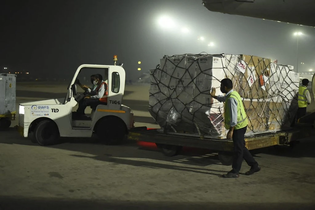 Ground staff unload medical aid from an aircraft sent from the UK upon its arrival at an airport in New Delhi, India. (File/AFP)
