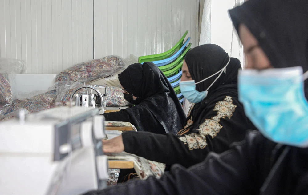 Women sew at the Jadaa rehabilitation camp for the displaced near the northern Iraqi city of Mosul, on May 11, 2022. (AFP)