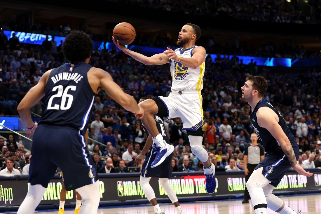 Stephen Curry of the Golden State Warriors drives to the basket against Spencer Dinwiddie #26 and Luka Doncic #77 of the Dallas. (AFP)