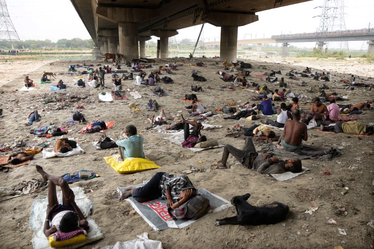 Homeless people sleep in the shade of an over-bridge to beat the heat wave in New Delhi on May 20, 2022. (AP/Manish Swarup)
