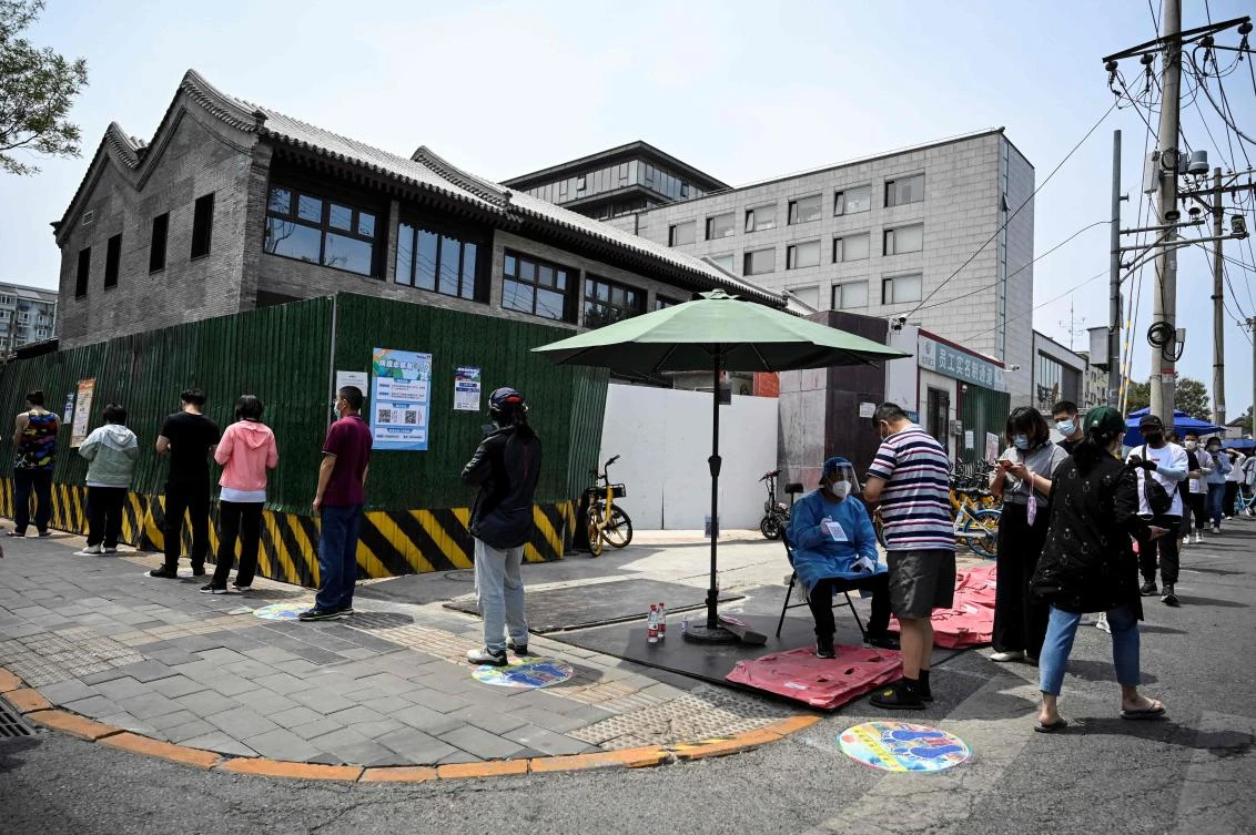 Beijing had already reduced public transport, requesting some shopping malls and other venues to close and sealing buildings where new cases were detected. Above, people line up to get tested for COVID-19. (AFP)