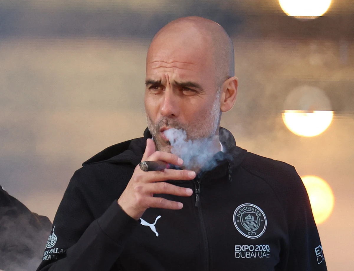 Manchester City manager Pep Guardiola celebrates with a cigar during the victory ceremony on Monday. (Reuters)