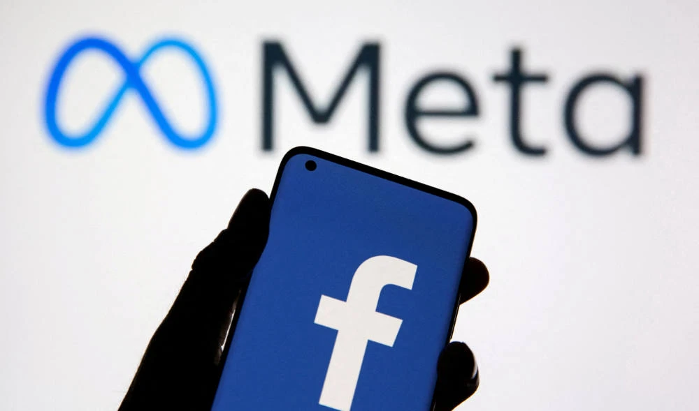 A smartphone with Facebook's logo is seen in front of displayed Facebook's new rebrand logo Meta in this illustration taken October 28, 2021. (REUTERS)