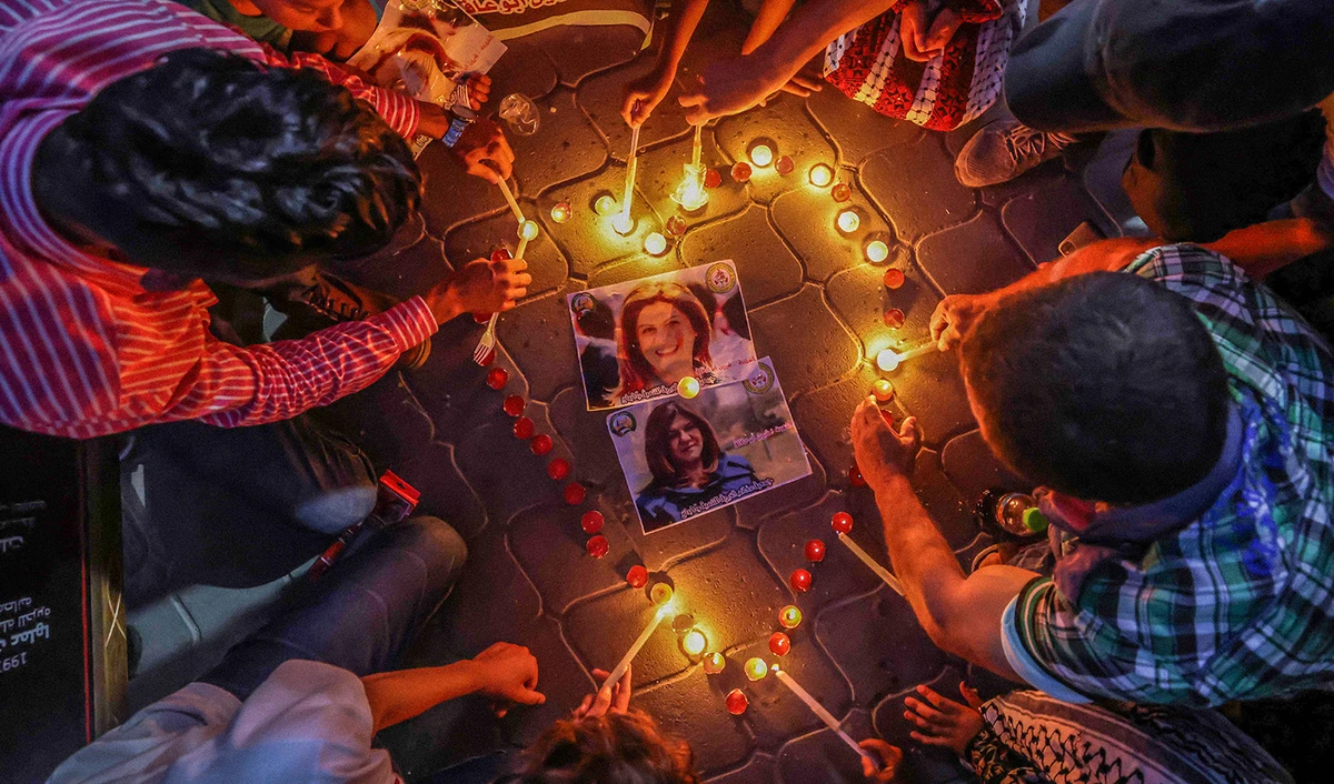 Gazans light candles during a vigil in honor of slain Palestinian Al-Jazeera journalist Shireen Abu Akleh in Gaza City on May 26, 2022. (AFP)