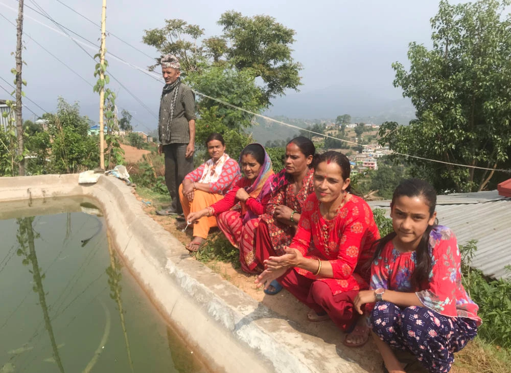 Residents of Kuinkel Thumka, a village in Nepal's Bagmati province, sit next to a conservation pond that supplies them with water during prolonged dry periods. (AN Photo)