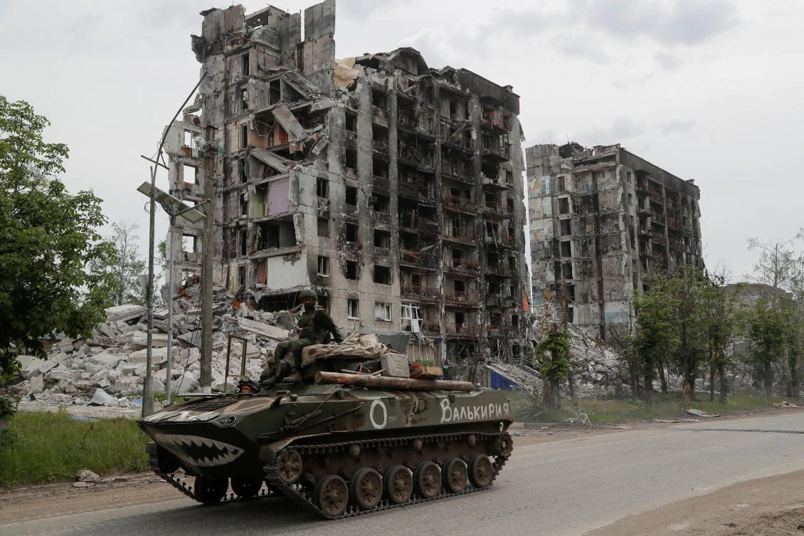 Service members of pro-Russian troops drive an armored vehicle along a street in the town of Popasna in the Luhansk Region, Ukraine on May 26, 2022. (Reuters)