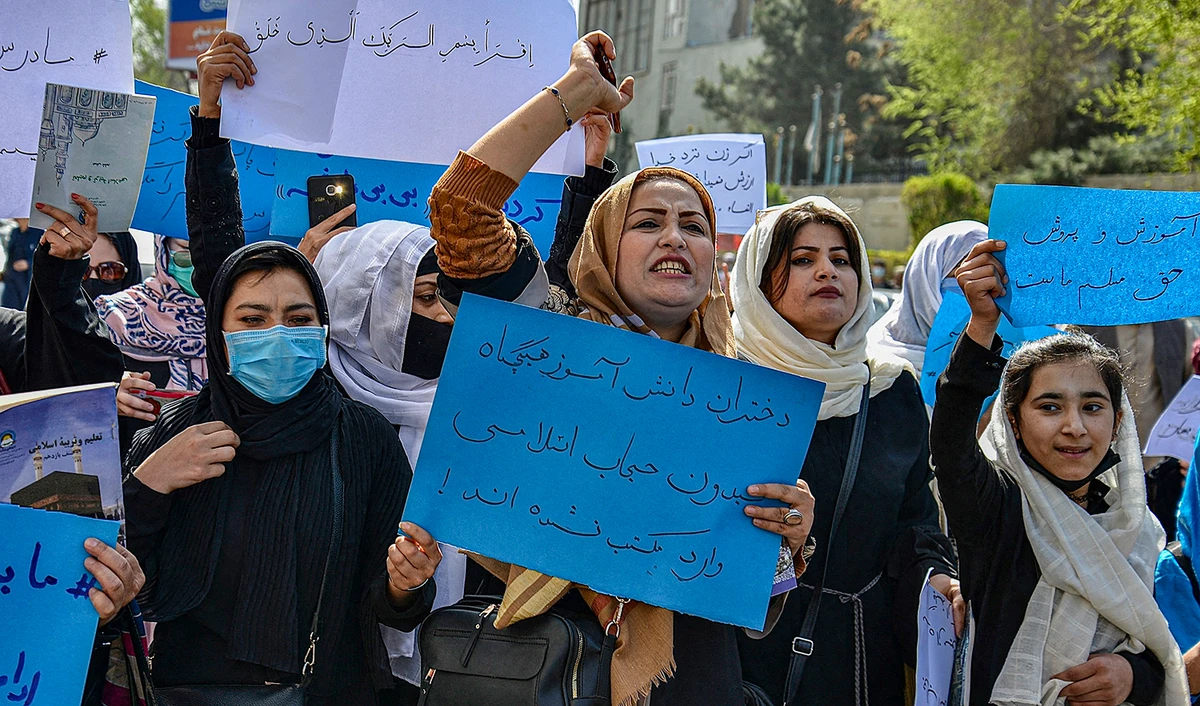 Afghan women and girls take part in a protest in front of the Ministry of Education in Kabul on March 26, 2022, demanding that high schools be reopened for girls. (AFP/File)