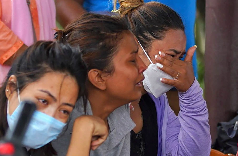 Family members and relatives of passengers on board the Twin Otter aircraft operated by Tara Air, weep outside the airport in Pokhara on May 29, 2022. (AFP)