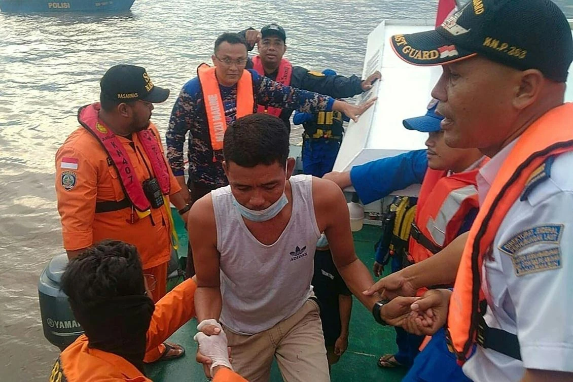 Rescue personnel assist a passenger from the KM Ladang Pertiwi ferry which ran out of fuel and sank in bad weather off the coast of Indonesia. (AFP)