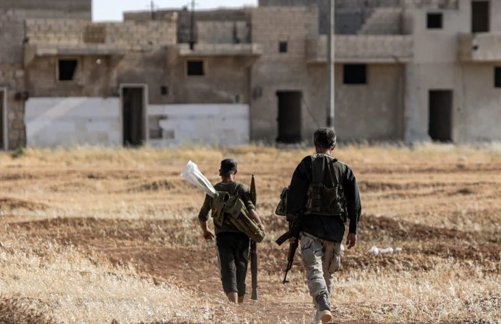 Turkish-backed Syrian fighters patrol a front opposite Syrian Democratic Forces (SDF) outside Manbij, Syria, June 8, 2022. (AFP)
