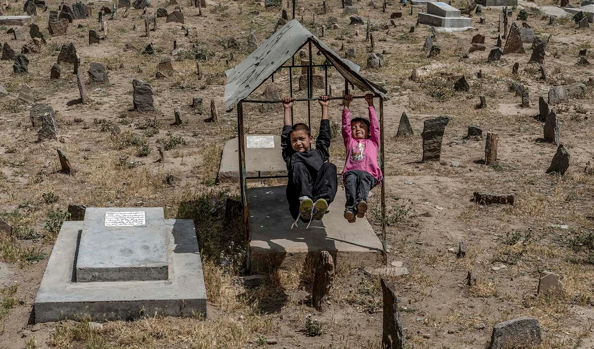 Afghan children play among the graves at a cemetery in Kabul, Afghanistan, on May 27, 2022. (AP/File)