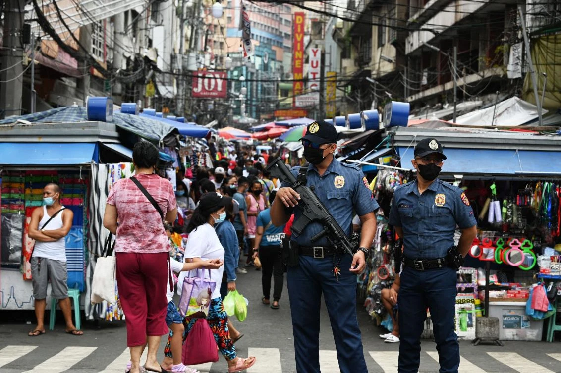 A policeman carrying an automatic rifle stands guard with a colleague along a popular market street in Manila on Wednesday as security forces are on heightened alert in the capital. (AFP)