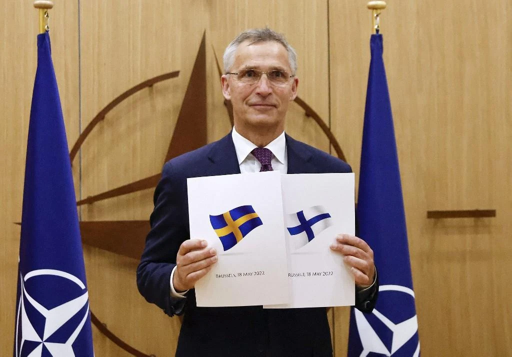 NATO Secretary-General Jens Stoltenberg poses with application documents presented by Finland and Sweden in Brussels, on May 18, 2022. (AFP)