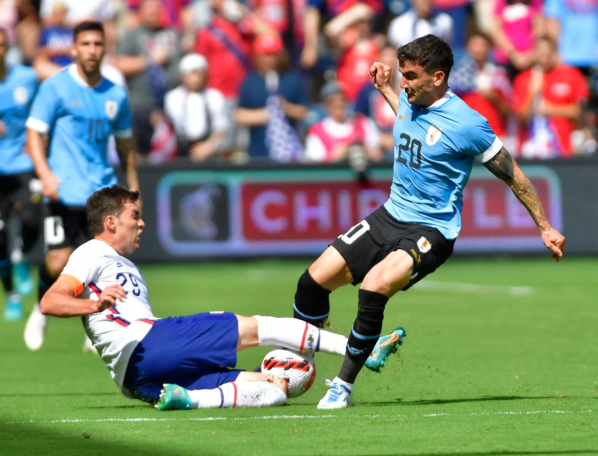 US player Joe Scally (29, left) slide tackles the ball away from Uruguay's Mauro Arambarri during an international friendly football match between the US and Uruguay at Children's Mercy Park in Kansas City, KS on June 5, 2022. (AFP)