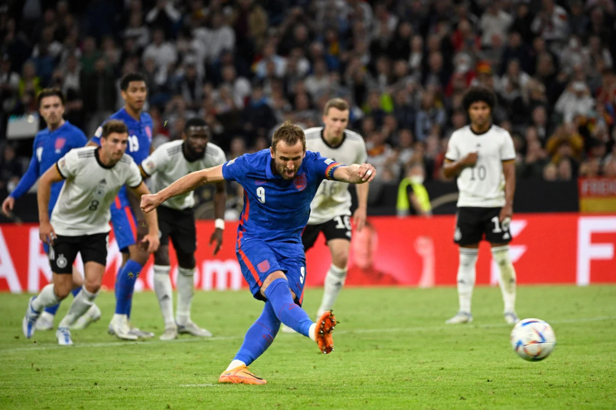 England's forward Harry Kane shoots from the penalty spot to score his team's equalizer during their UEFA Nations League football match against Germany in Munich on June 7, 2022. (AFP)