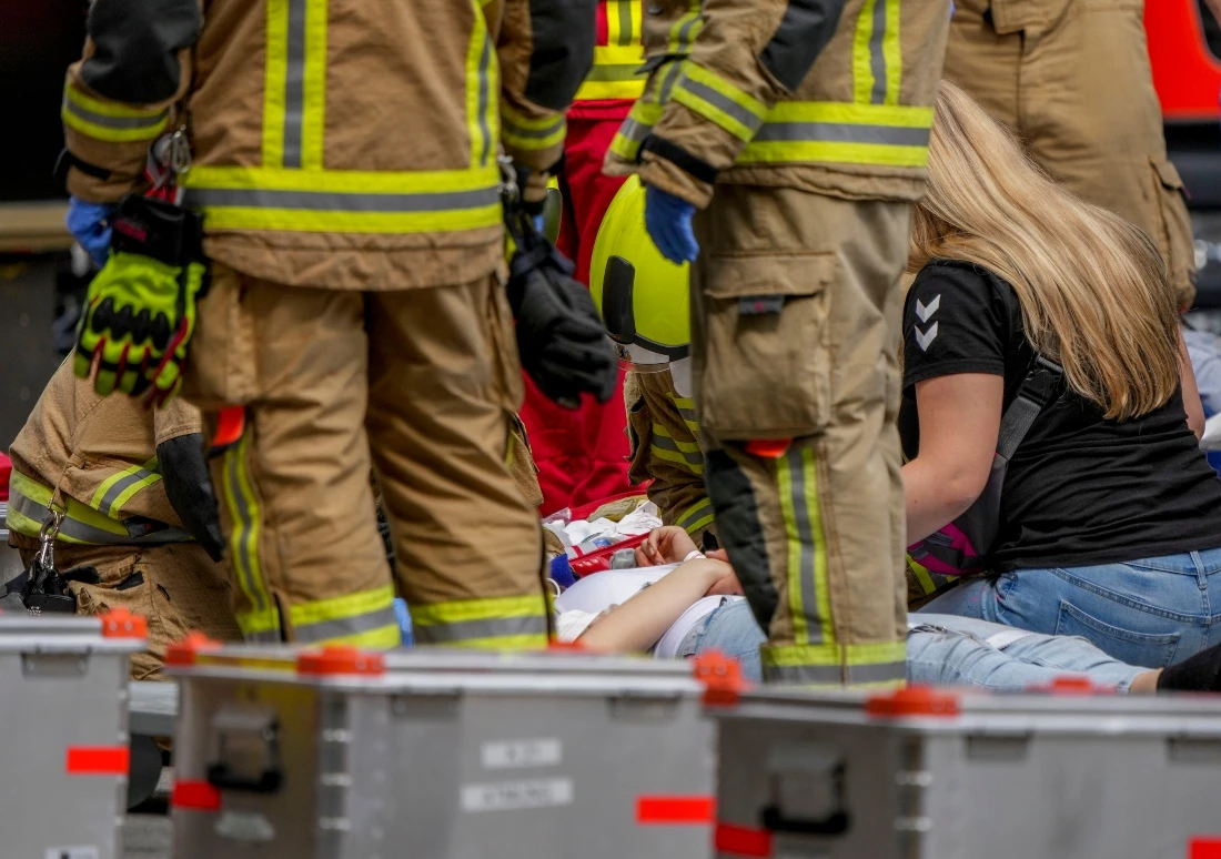 Rescue workers help an injured person after a car crashed into a crowd of people in central Berlin, Germany, Wednesday, June 8, 2022. (AP/Michael Sohn)