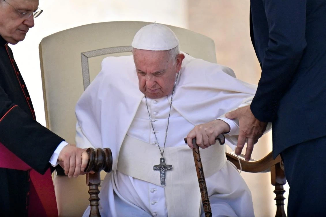 Pope Francis is helped get up from his seat at the end of the weekly general audience on Wednesday at St. Peter’s Square in The Vatican. (AFP)