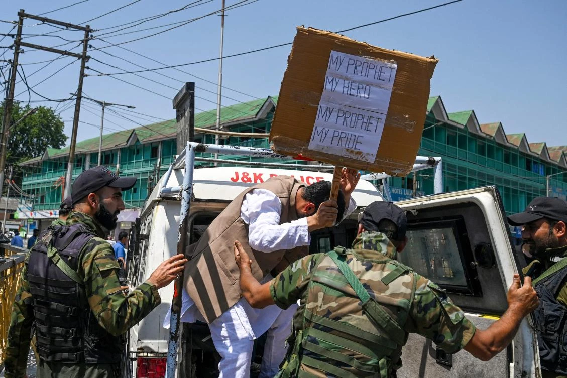 Policemen detain a man during a protest in Srinagar on June 10, 2022. (AFP)