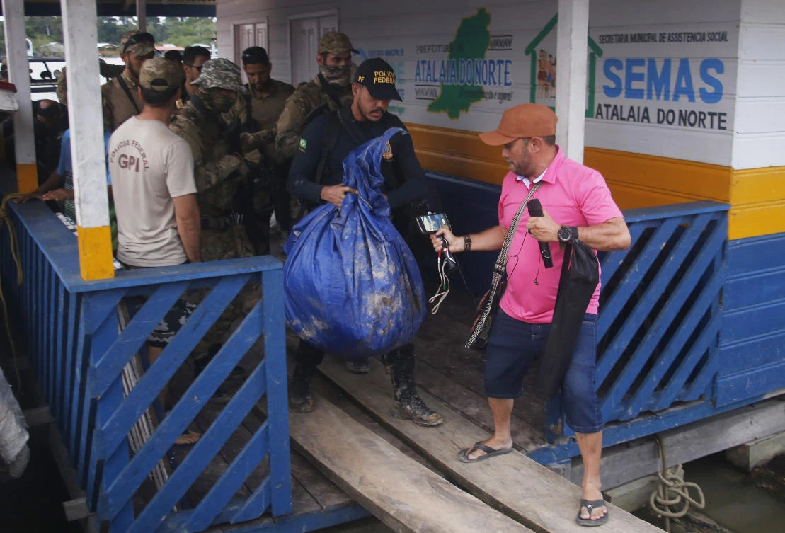 Brazilian federal police officers arrive at the pier with items found during a search for indigenous expert Bruno Pereira and freelance British journalist Dom Phillips in Atalaia do Norte. (AP)