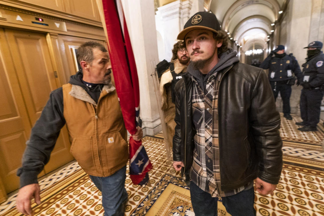 Kevin Seefried, left, walks on a hallway after a confrontation with police officers outside the Senate Chamber inside the Capitol on Jan. 6, 2021 in Washington. (AP)