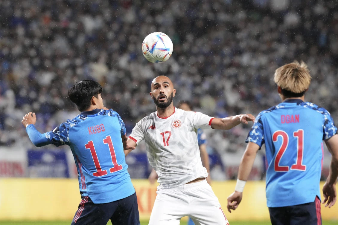 Tunisia’s Issam Jebali battles for the ball with Takefusa Kubo and Ritsu Doan of Japan during their match at the Kirin Cup soccer tournament in Suita, west Japan, on Tuesday. (AP)