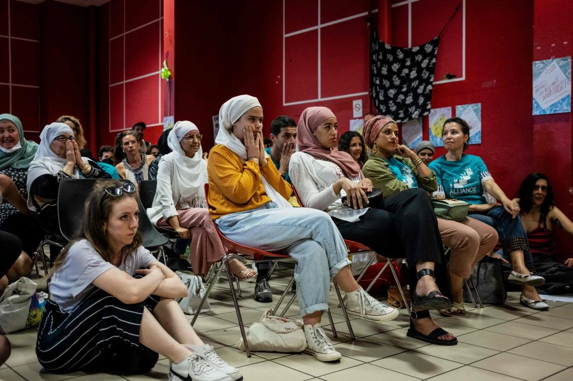 Members of the pro-burkini association Alliance Citoyenne watch a Municipal Council meeting on a TV screen during a council vote to allow or not the wearing of the burkini in the city’s swimming pools, in Grenoble. (AFP)
