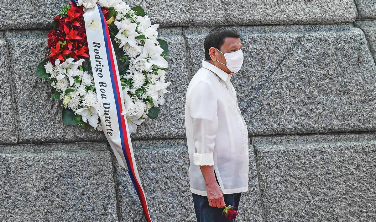 Philippine President Rodrigo Duterte holds a single rose flower at a ceremony during the country’s 124th Independence Day in Manila. (AFP)