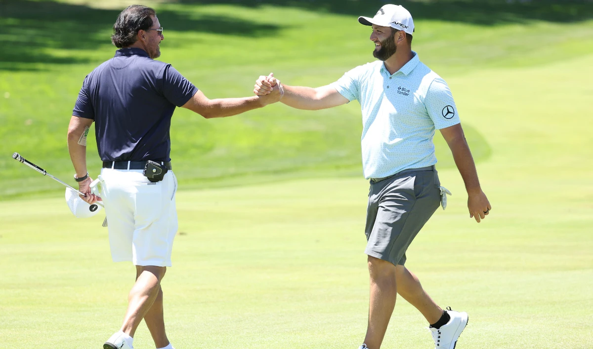 Phil Mickelson of the US congratulates Jon Rahm of Spain after Rahm holed a shot for eagle on the fourth hole during a practice round prior to the US Open on June 14, 2022 in Brookline, Massachusetts. (AFP)