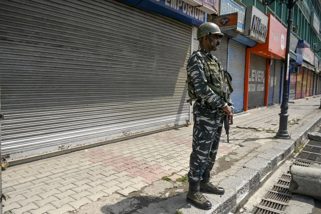 Above, an Indian paramilitary trooper stands guard along a street in front of closed shops during a strike in Srinagar on June 10, 2022. (AFP)