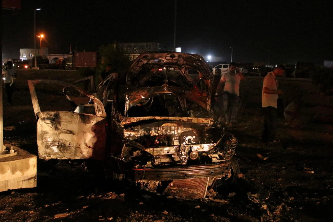People inspect the wreckage of the car of journalist Saber al-Haidary who was killed by planted explosive device in Aden. (REUTERS)