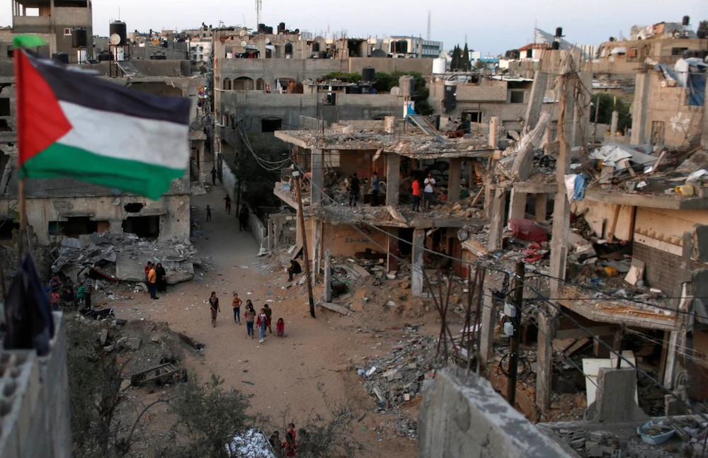 A Palestinian flag flies as the ruins of houses, which were destroyed by Israeli air strikes during the Israeli-Palestinian fighting, are seen, in Gaza Strip, May 25, 2021. (Reuters/File Photo)