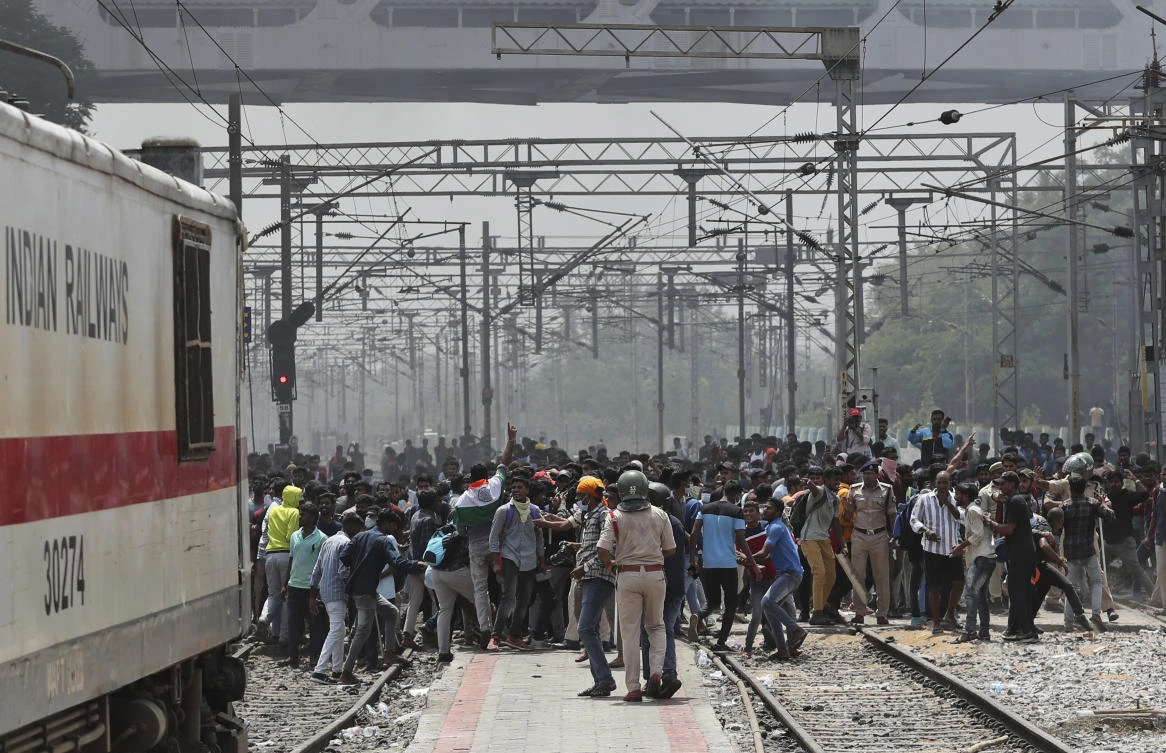 Hundreds of angry youths gave vent to their ire by burning train coaches, vandalizing railroad property and blocking rail tracks and highways as backlash continues against a new short-term government recruitment scheme for the military. (AP)
