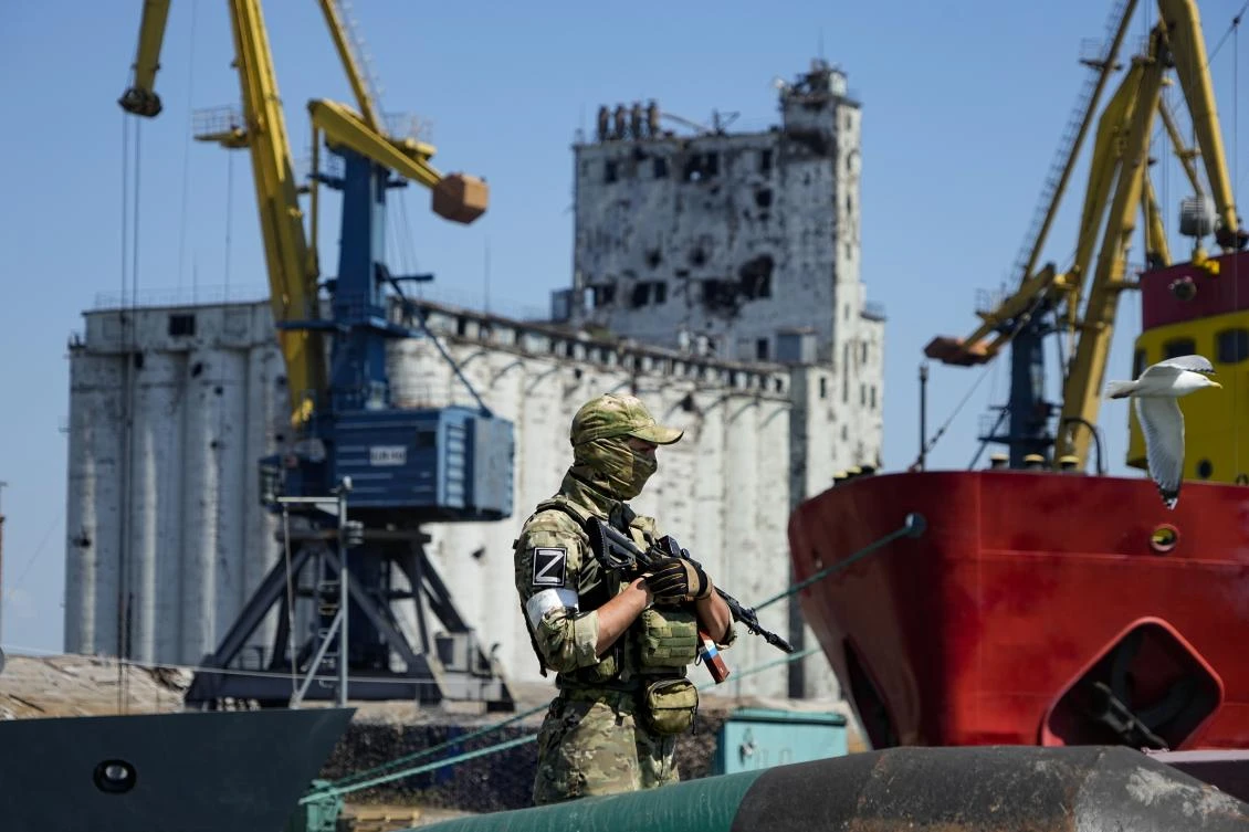 A Russian soldier guards a pier with the grain storage in the background at an area of the Mariupol Sea Port which has recently started its work after heavy fighting in Mariupol, on June 12. (AP)