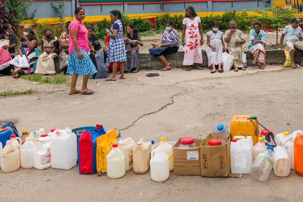 People queue up to buy kerosene for domestic use at a supply station in Colombo on June 17, 2022. (AFP)