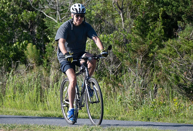 US President Joe Biden rides his bicycle at Gordon's Pond State Park in Rehoboth Beach, Delaware, on June 18, 2022. (AFP)