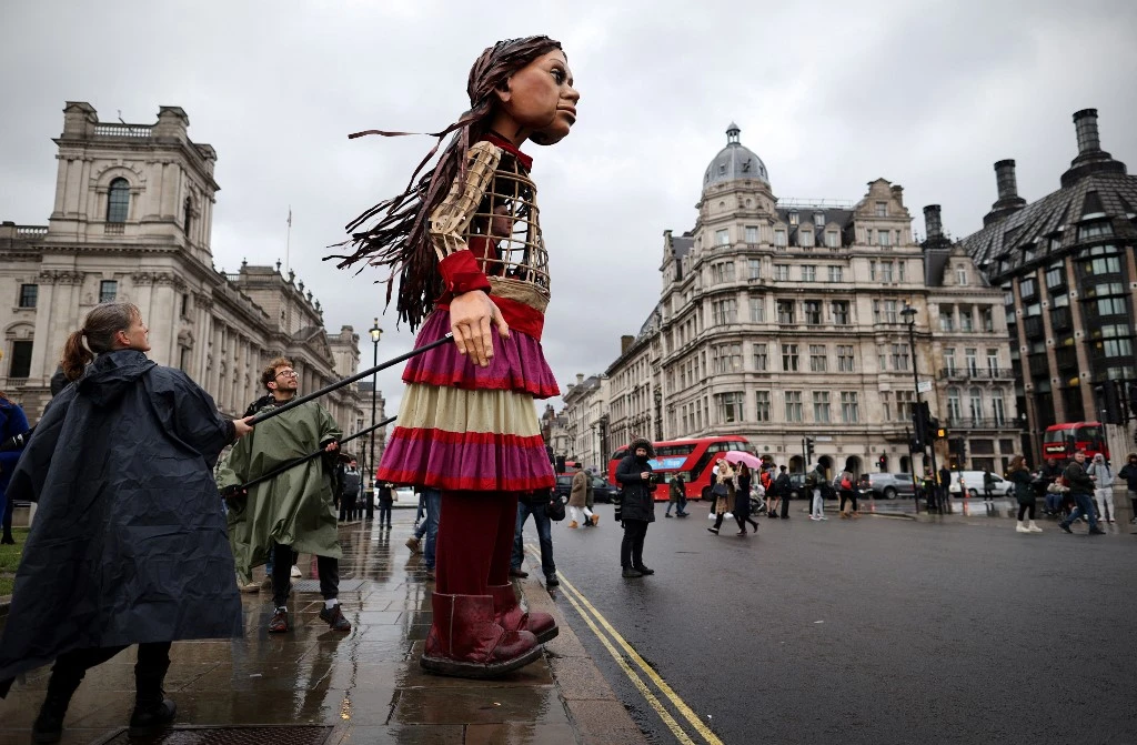 Little Amal, a giant puppet depicting a Syrian refugee girl, arrives in Parliament Square opposite the House of Commons in London. (File/AFP)