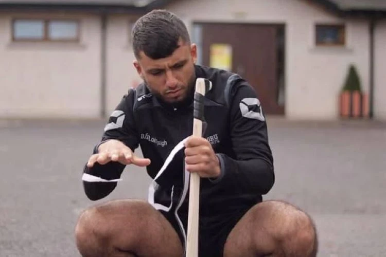 Abood Al-Jumaili regrips a hurley. (Twitter Photo)