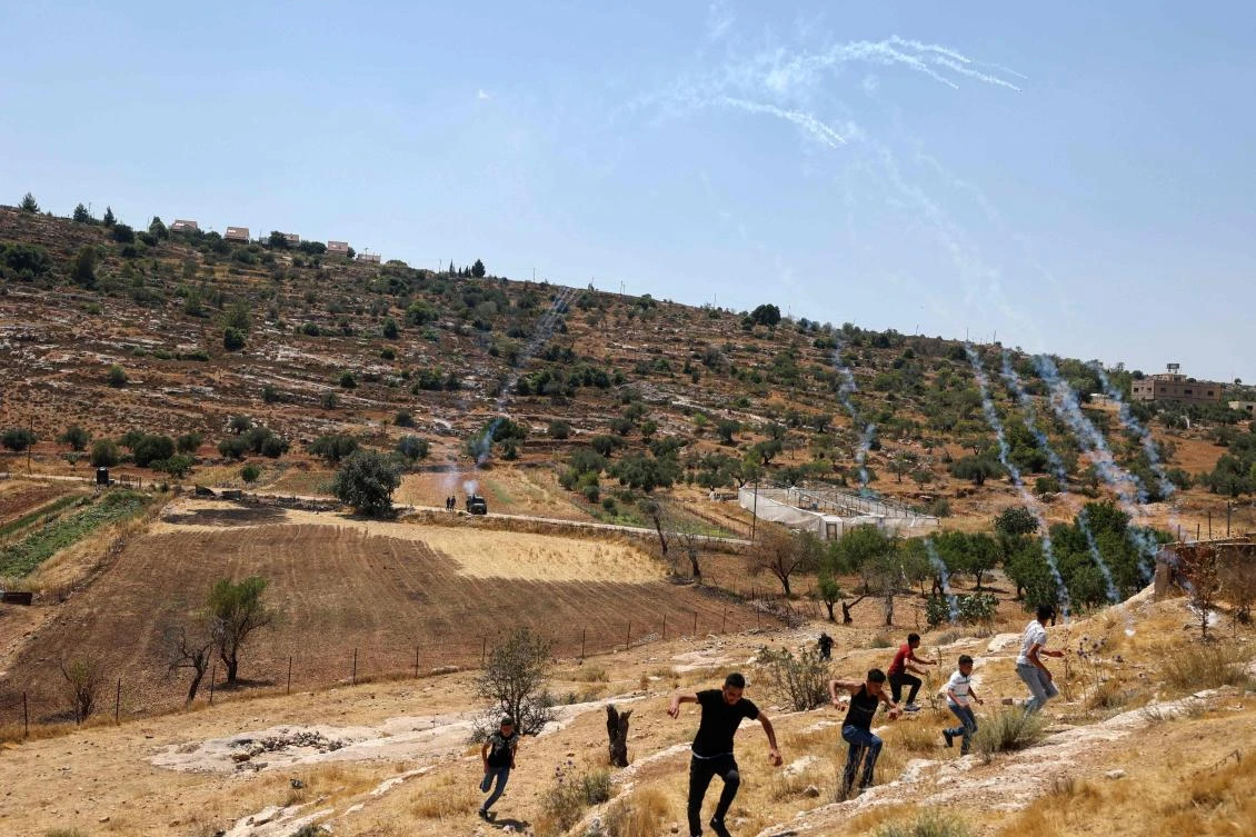 Palestinian demonstrators move away from Israeli tear gas while protesting attempts by Israeli settlers from the settlement of Eli in the occupied West Bank. (AFP)