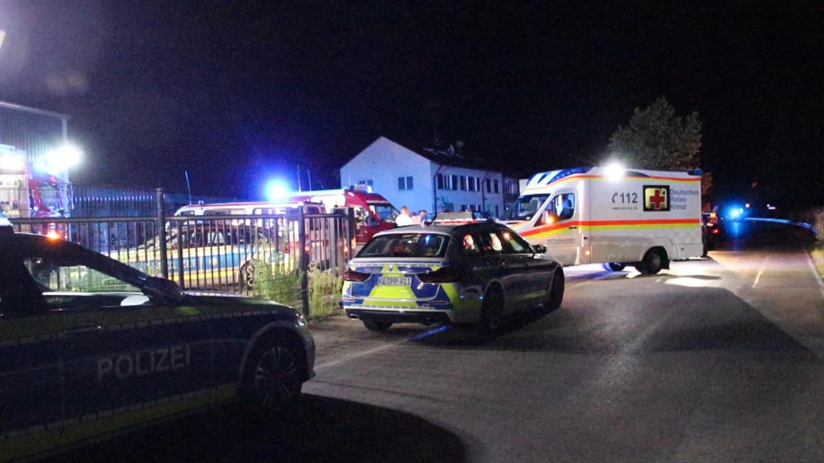 Police and emergency services stand at an asylum seeker shelter after a knife attack in Kressbronn, Germany on June 26, 2022. (dpa via AP)