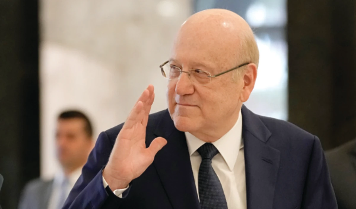 Lebanese Prime Minister-designate Najib Mikati, waves as he arrives for a meeting at the Presidential Palace in Baabda, east of Beirut. (AP)
