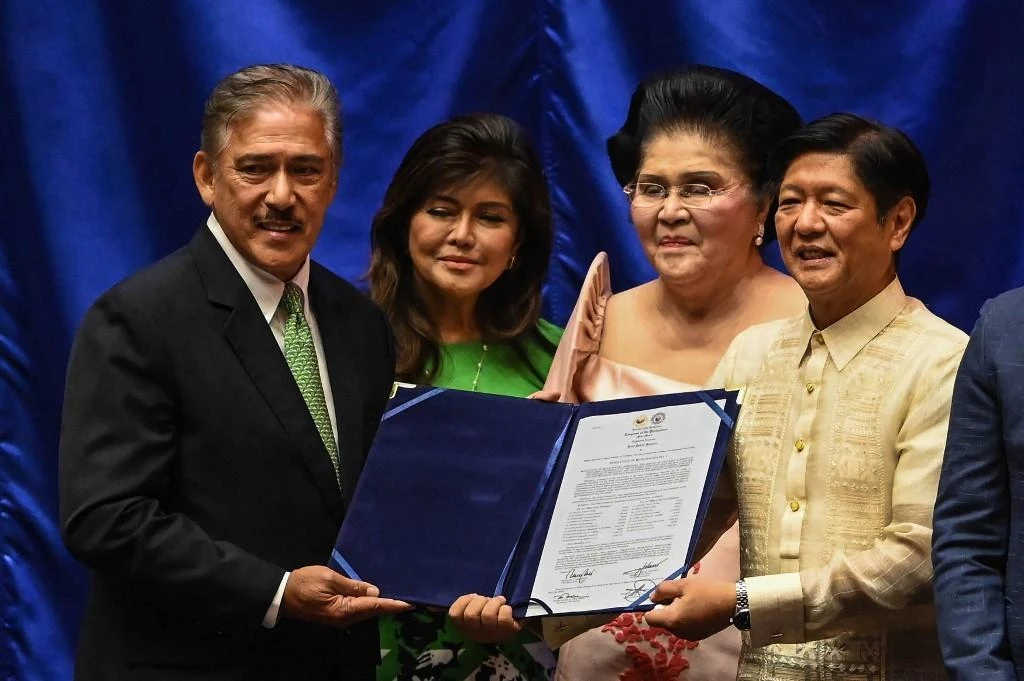 Ferdinand Marcos Jr, right, with his certificate of proclamation as the country’s president with Senate President Vicente Sotto III, as his mother Imelda Marcos, second right, and Senator Imee Marcos-Manotoc look on. (AFP)